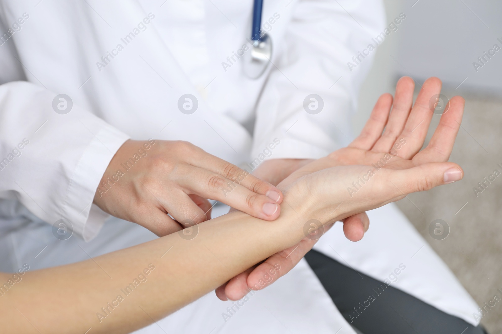Doctor checking woman's pulse with fingers indoors, closeup Photo of Doctor checking woman's pulse with fingers indoors, closeup