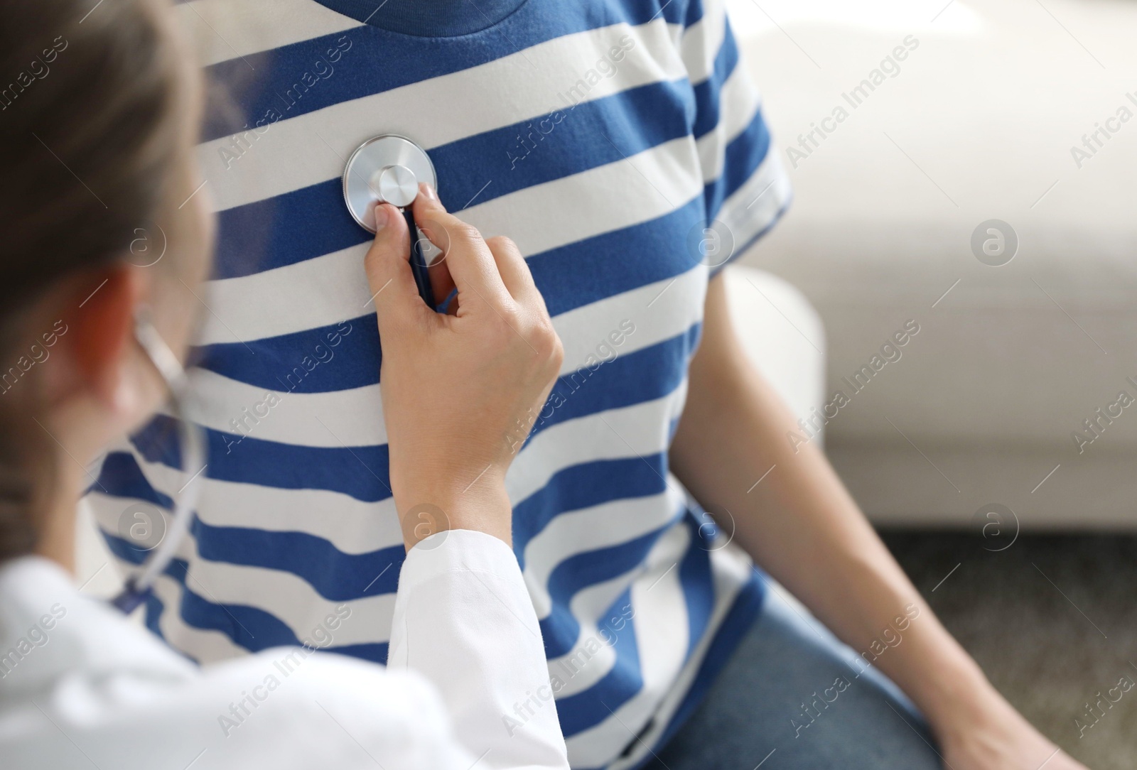 Doctor checking woman's heartbeat with stethoscope indoors, closeup Photo of Doctor checking woman's heartbeat with stethoscope indoors, closeup