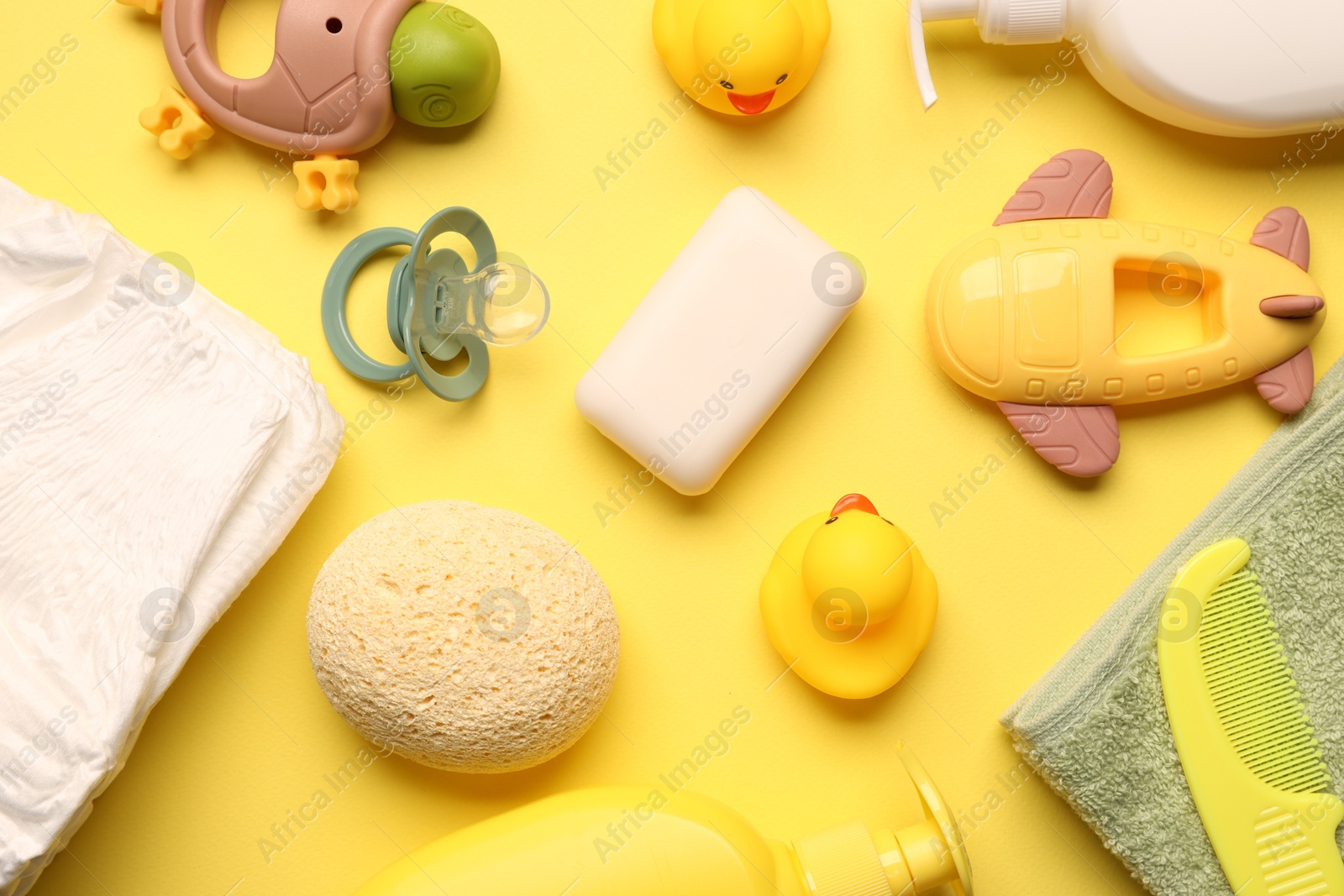Photo of Baby bath accessories on yellow background, flat lay