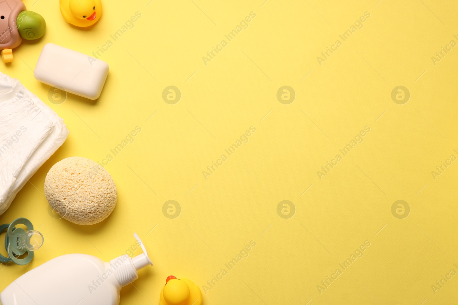 Photo of Baby bath accessories on yellow background, flat lay. Space for text