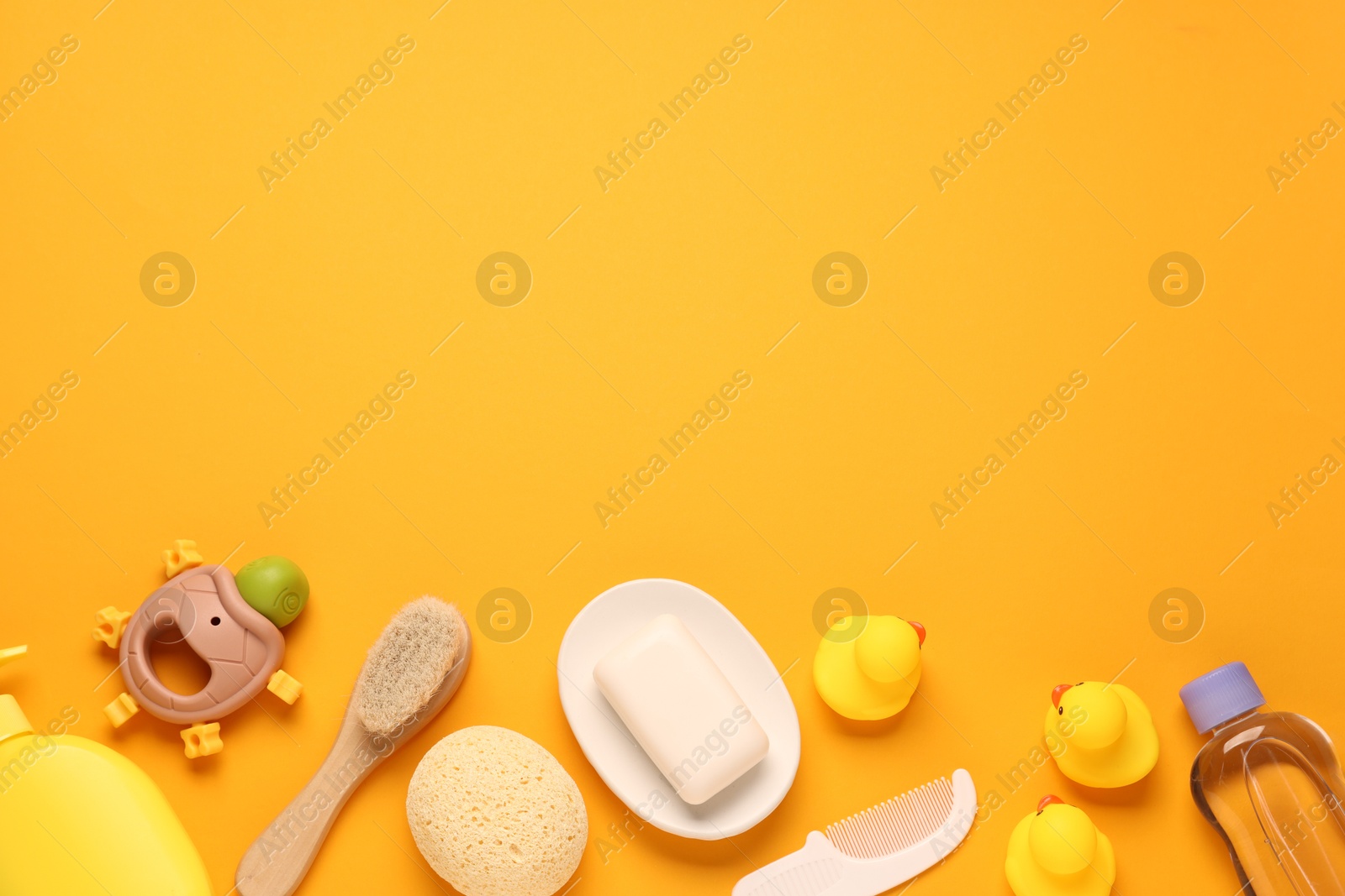 Photo of Baby bath accessories and care products on orange background, flat lay. Space for text
