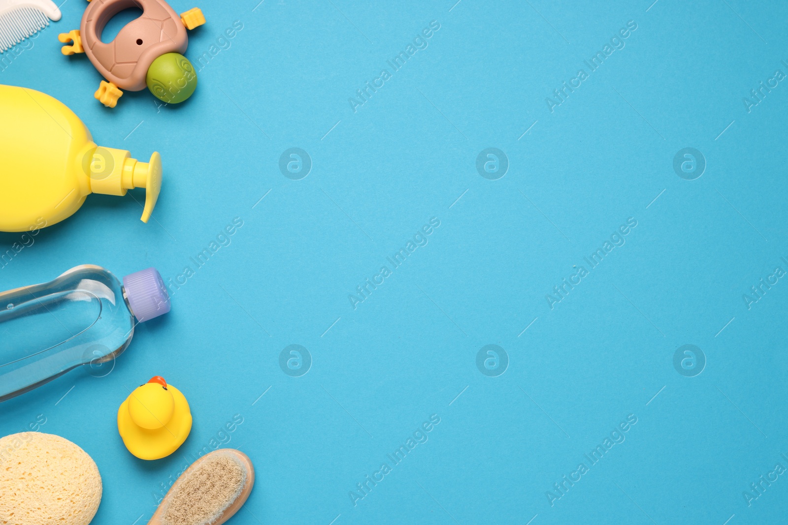Photo of Baby bath accessories and care products on light blue background, flat lay. Space for text