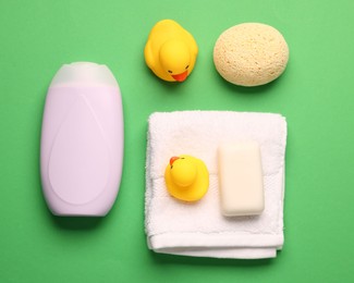 Photo of Baby bath accessories on green background, flat lay