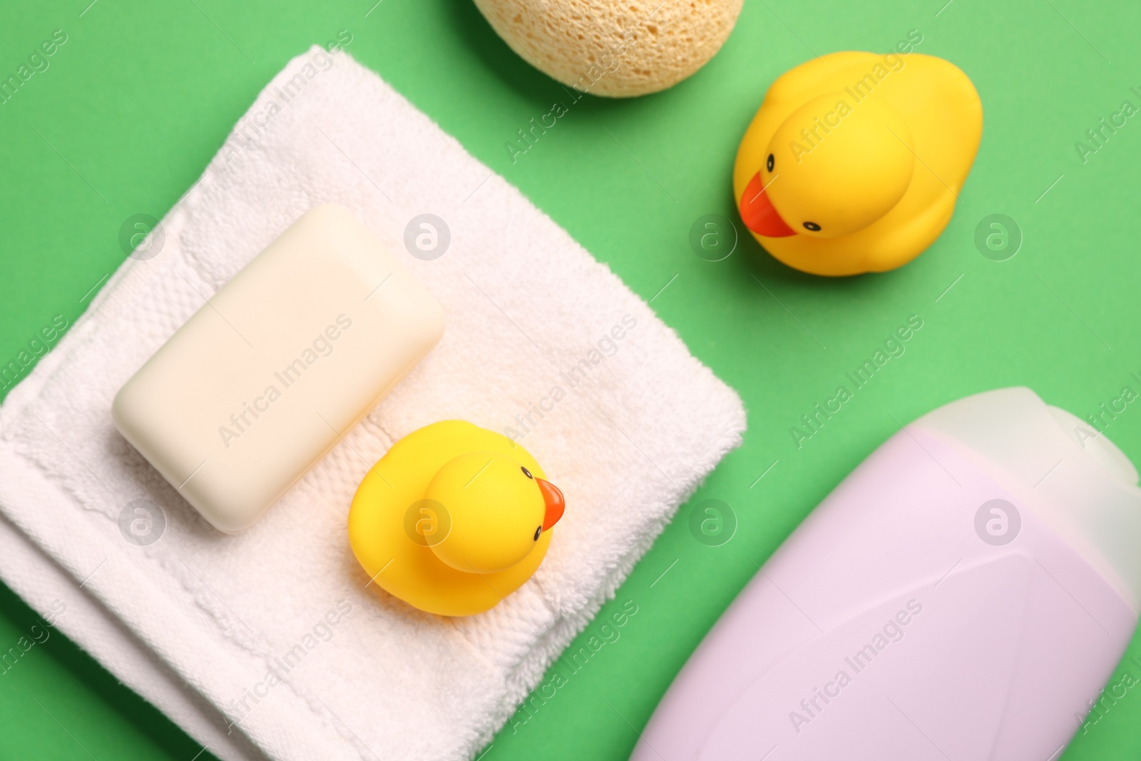 Photo of Baby bath accessories on green background, flat lay