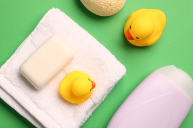 Photo of Baby bath accessories on green background, flat lay