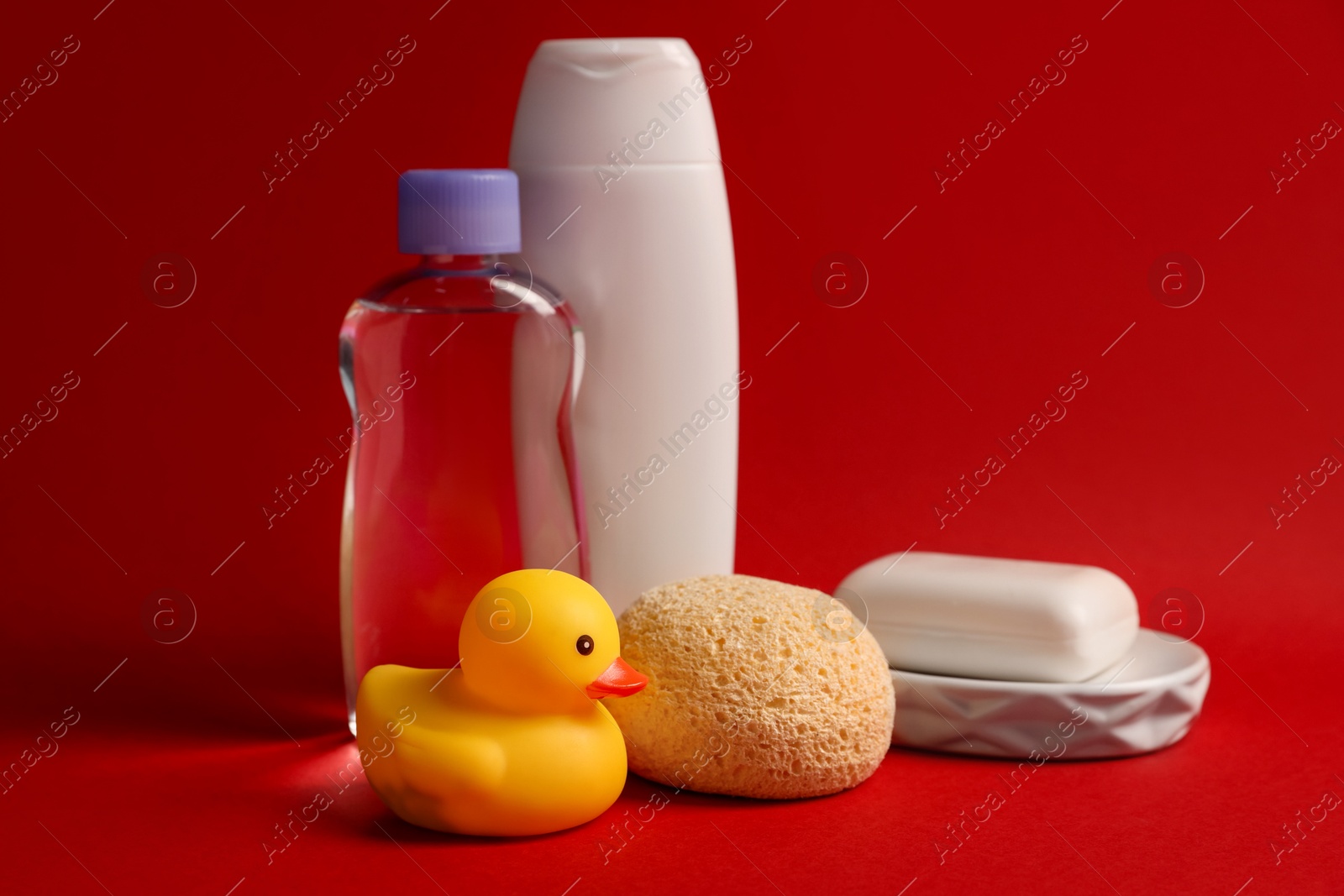 Photo of Baby bath accessories and care products on red background