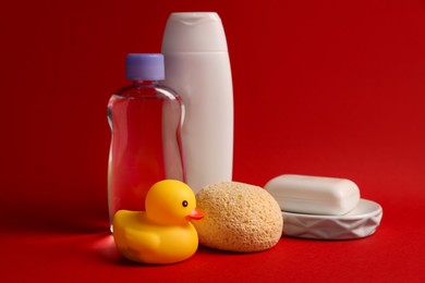 Photo of Baby bath accessories and care products on red background