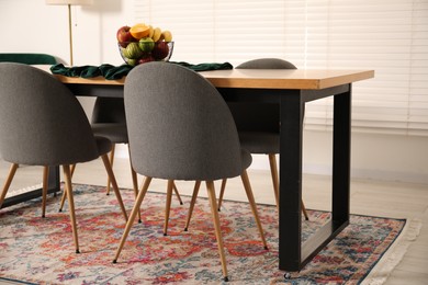 Photo of Bowl of fruits on wooden table in dining room. Interior design