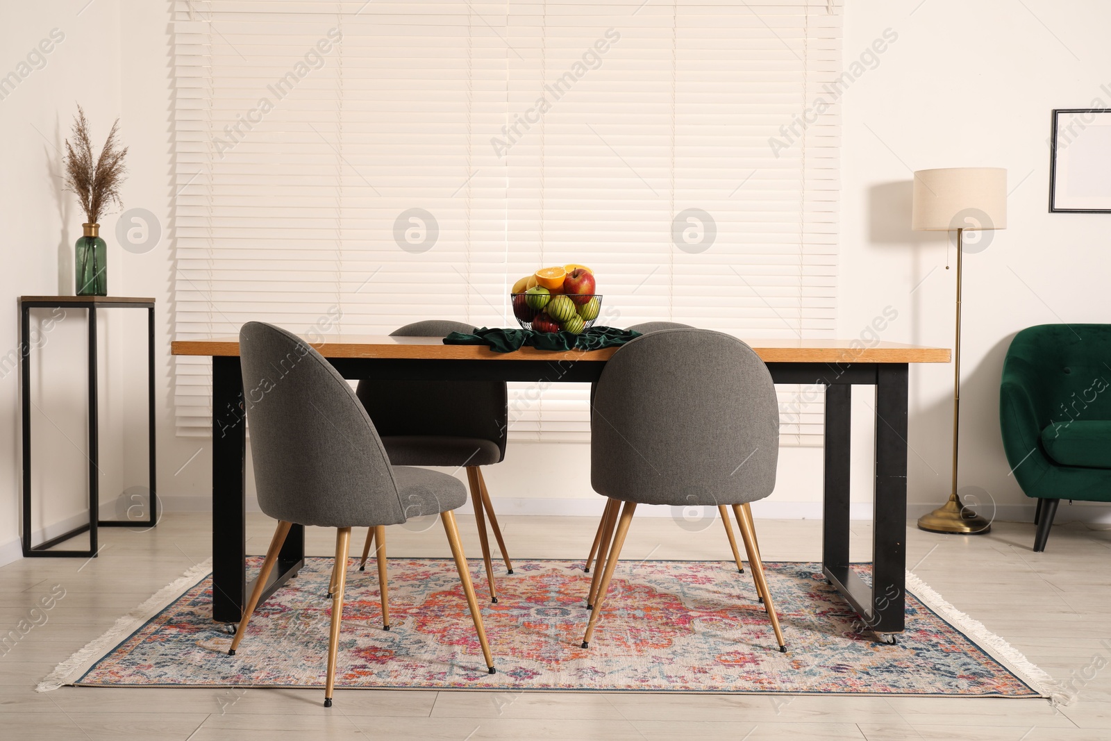 Bowl of fruits on wooden table in dining room. Interior design Photo of Bowl of fruits on wooden table in dining room. Interior design