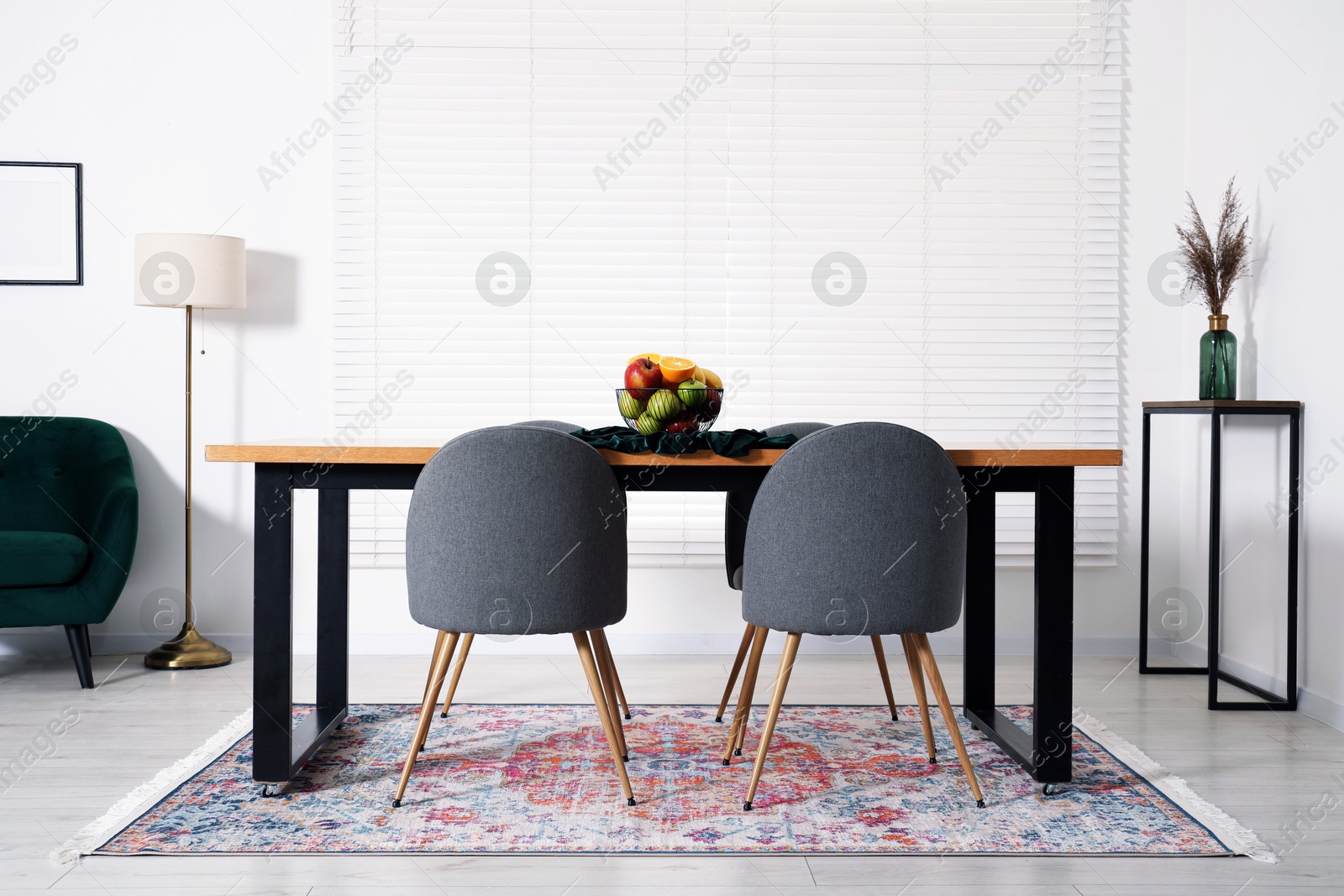 Bowl of fruits on wooden table in dining room. Interior design Photo of Bowl of fruits on wooden table in dining room. Interior design