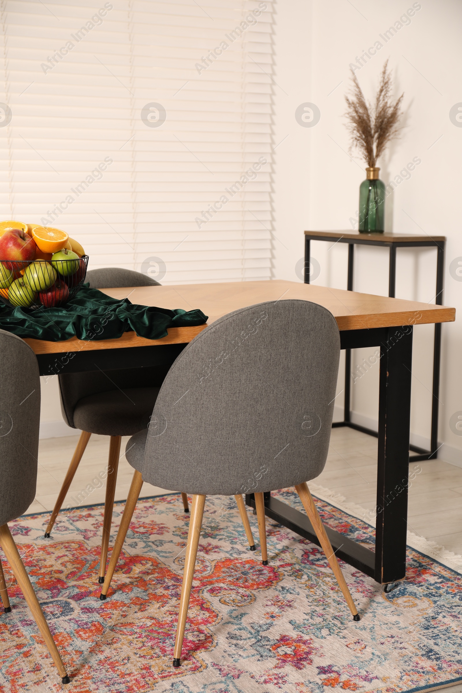 Bowl of fruits on wooden table in dining room. Interior design Photo of Bowl of fruits on wooden table in dining room. Interior design