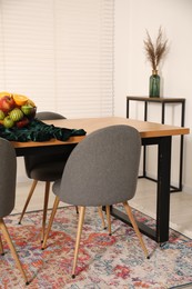Photo of Bowl of fruits on wooden table in dining room. Interior design