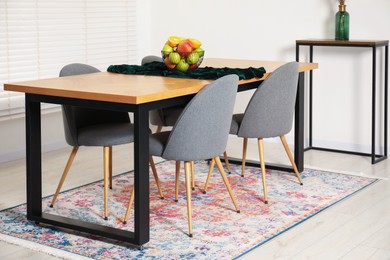 Photo of Bowl of fruits on wooden table in dining room. Interior design