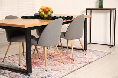 Photo of Bowl of fruits on wooden table in dining room. Interior design