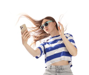 Photo of Woman in sunglasses with beautiful long hair using smartphone on white background, low angle view