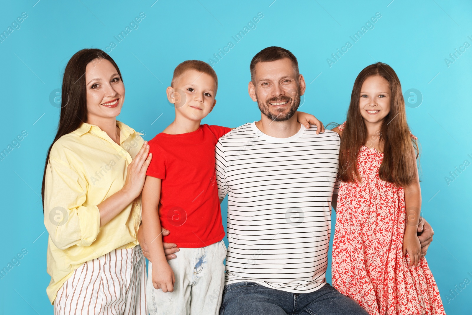 Portrait of happy family on light blue background Photo of Portrait of happy family on light blue background