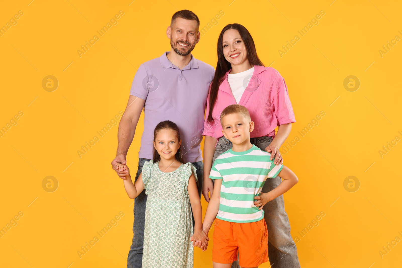 Photo of Portrait of happy family on yellow background