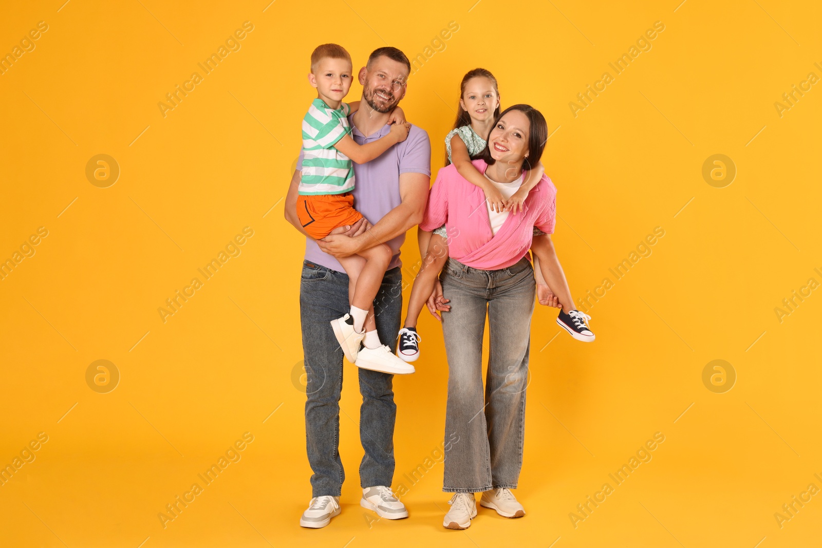 Photo of Lovely family posing together on yellow background