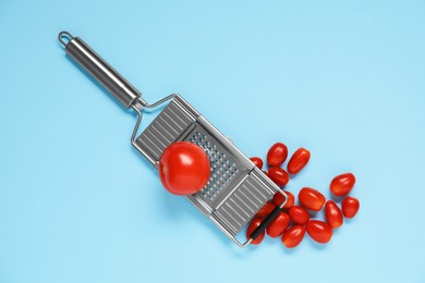 Photo of Fresh tomatoes and grater on light blue background, flat lay