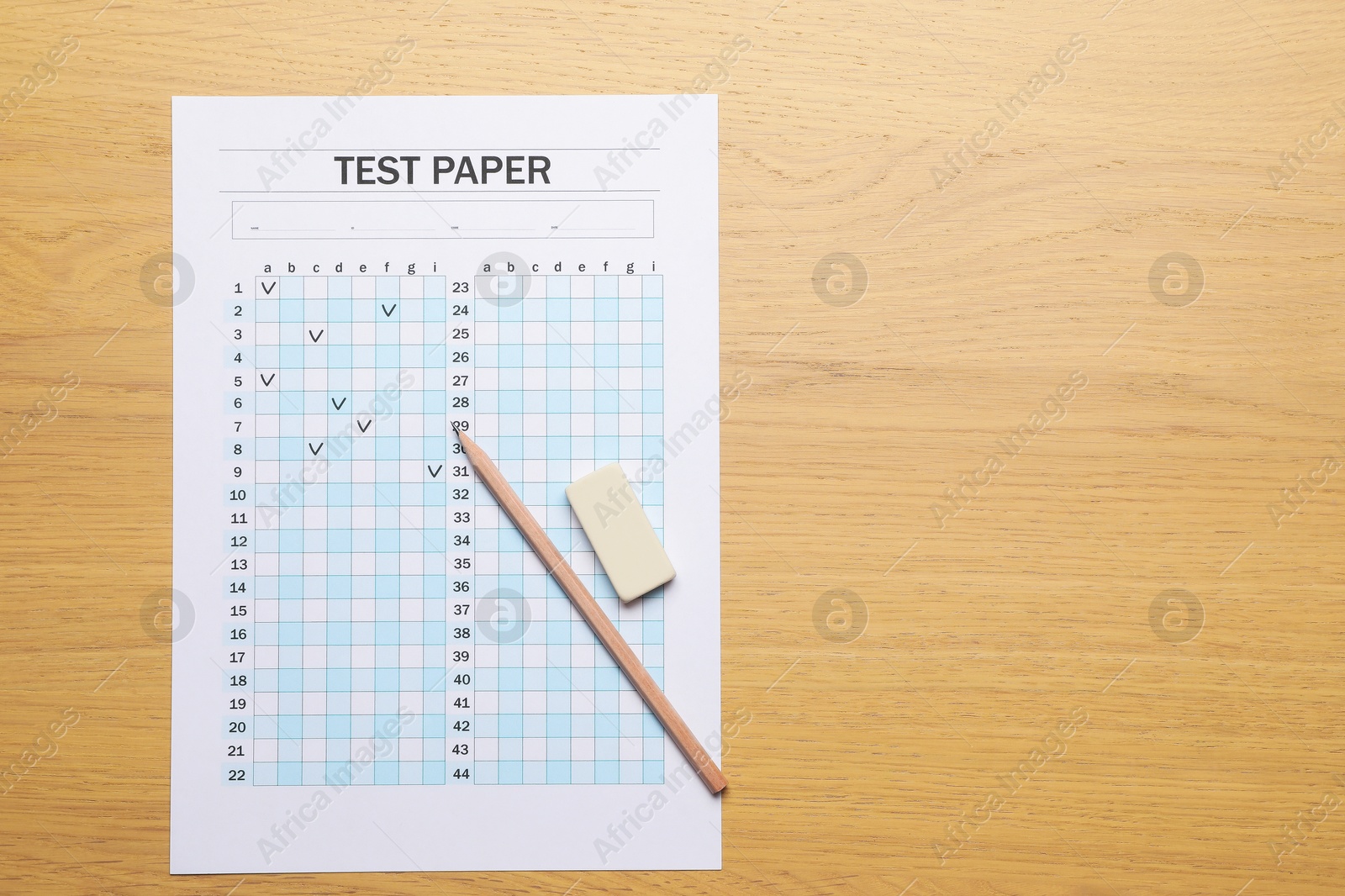 Student passing exam. Answer sheet, eraser and pencil on wooden table, flat lay. Space for text Photo of Student passing exam. Answer sheet, eraser and pencil on wooden table, flat lay. Space for text