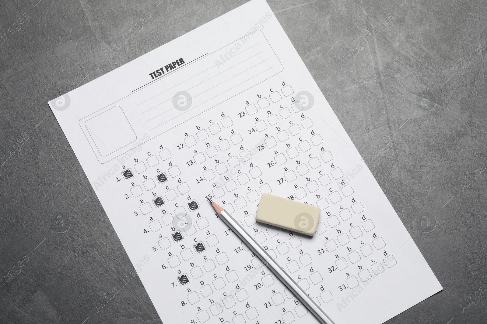 Answer sheet, pencil and eraser on gray textured table, flat lay. Student passing exam Photo of Answer sheet, pencil and eraser on gray textured table, flat lay. Student passing exam