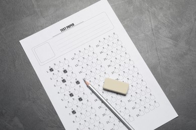 Photo of Answer sheet, pencil and eraser on gray textured table, flat lay. Student passing exam
