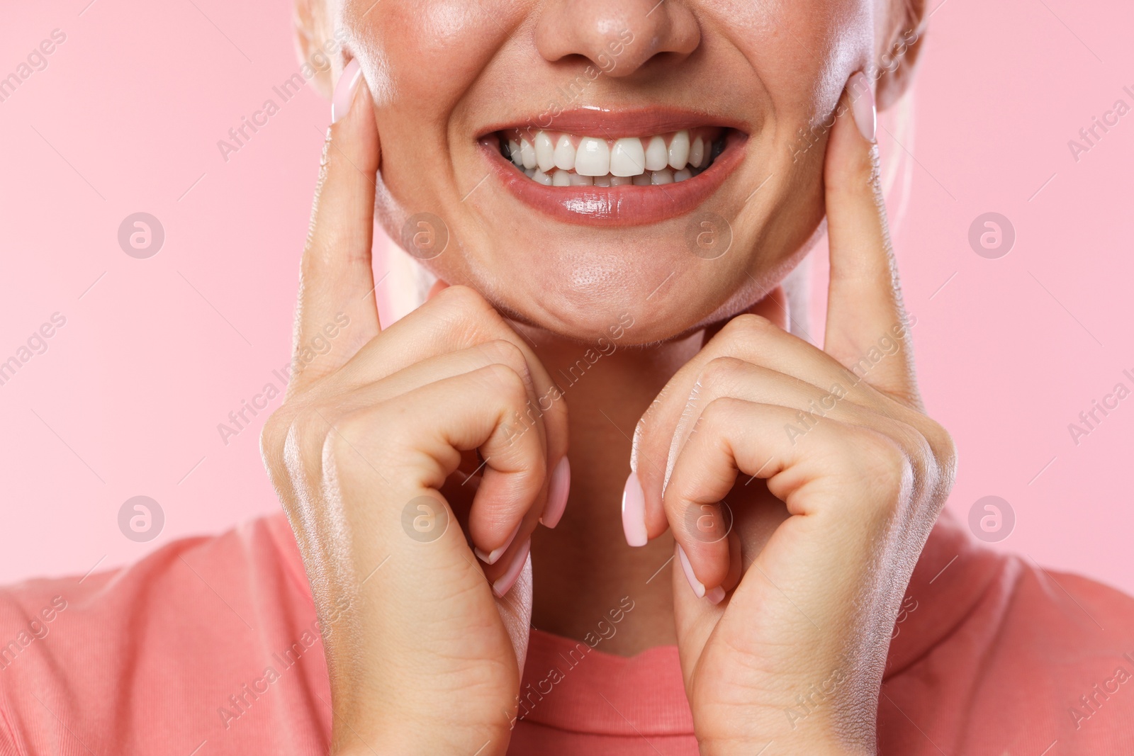 Photo of Woman with beautiful healthy teeth on pink background, closeup