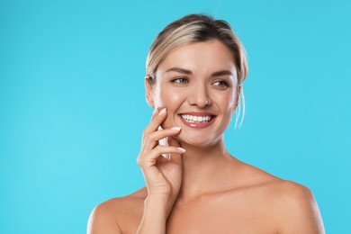 Photo of Woman with beautiful healthy teeth on light blue background