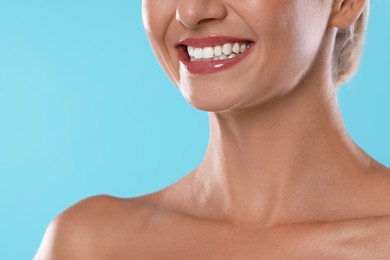 Photo of Woman with beautiful healthy teeth on light blue background, closeup. Space for text