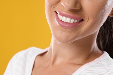 Photo of Woman with beautiful healthy teeth on yellow background, closeup
