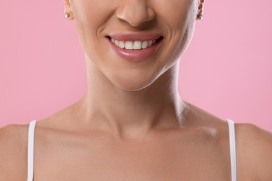 Photo of Woman with beautiful healthy teeth on pink background, closeup