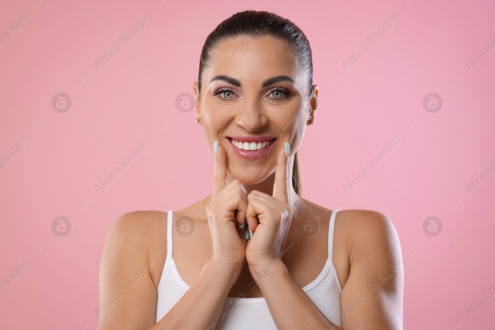 Photo of Woman with beautiful healthy teeth on pink background