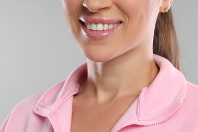 Photo of Woman with beautiful healthy teeth on light grey background, closeup