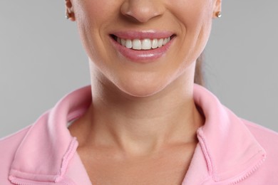 Photo of Woman with beautiful healthy teeth on light grey background, closeup