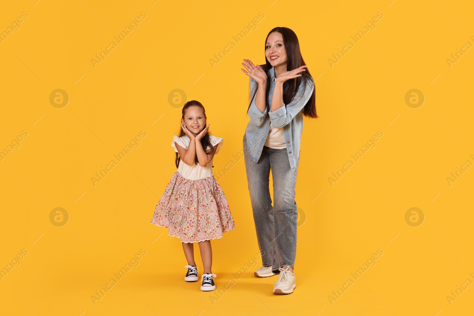 Photo of Mother and daughter having fun on yellow background