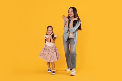 Photo of Mother and daughter having fun on yellow background