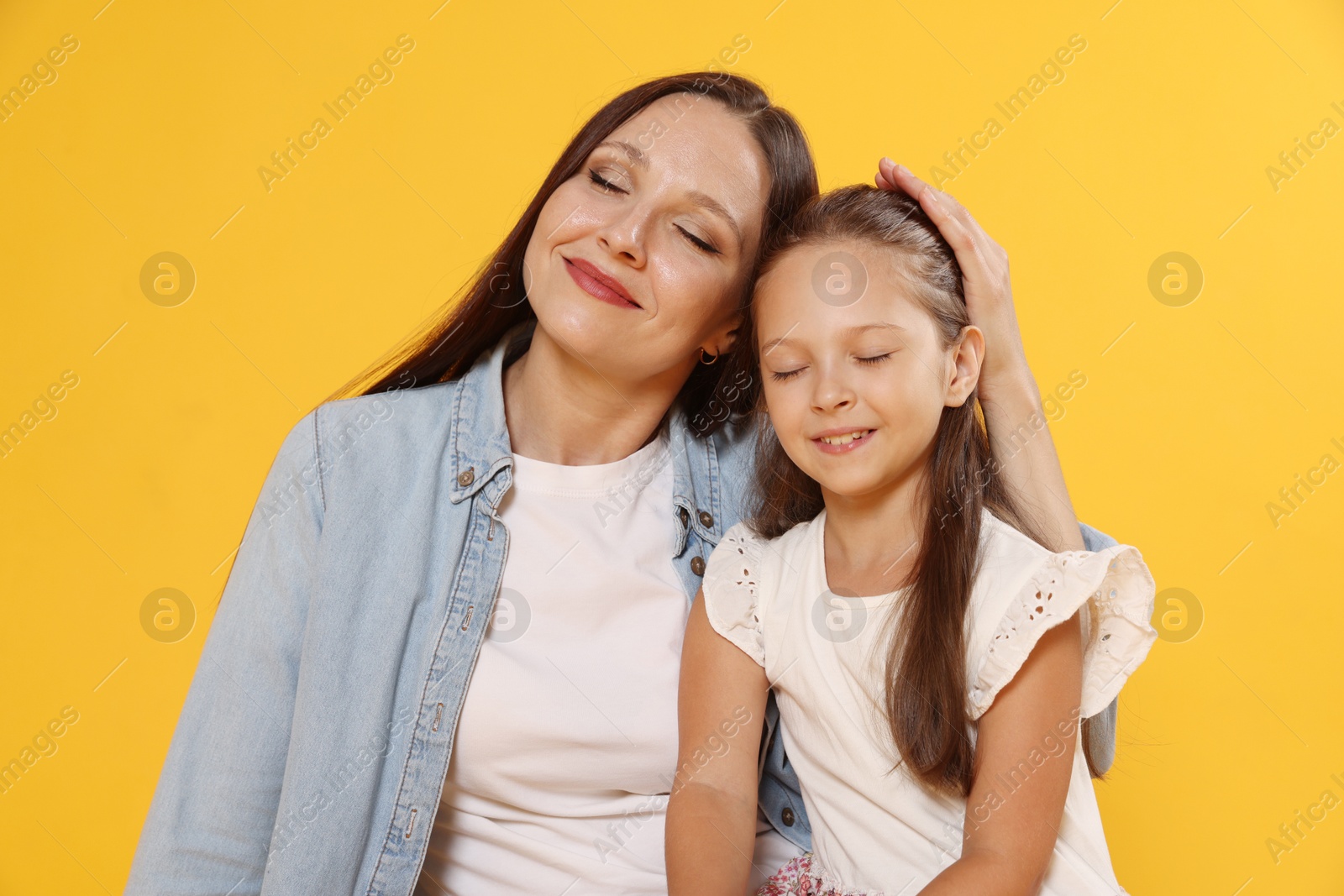 Photo of Lovely mother and daughter on yellow background
