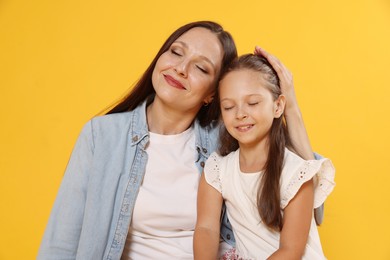 Photo of Lovely mother and daughter on yellow background