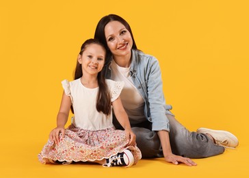 Photo of Lovely mother and daughter on yellow background