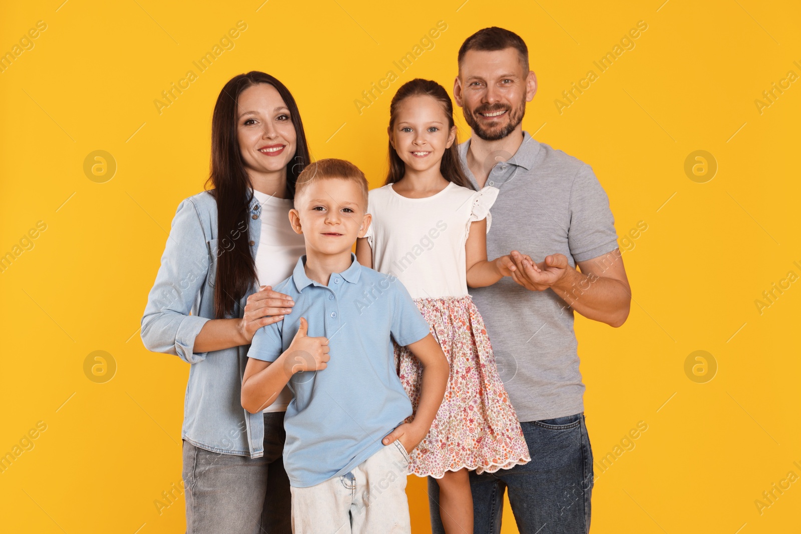 Photo of Portrait of happy family on yellow background