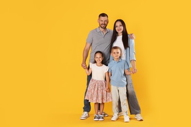 Photo of Lovely family posing together on yellow background. Space for text