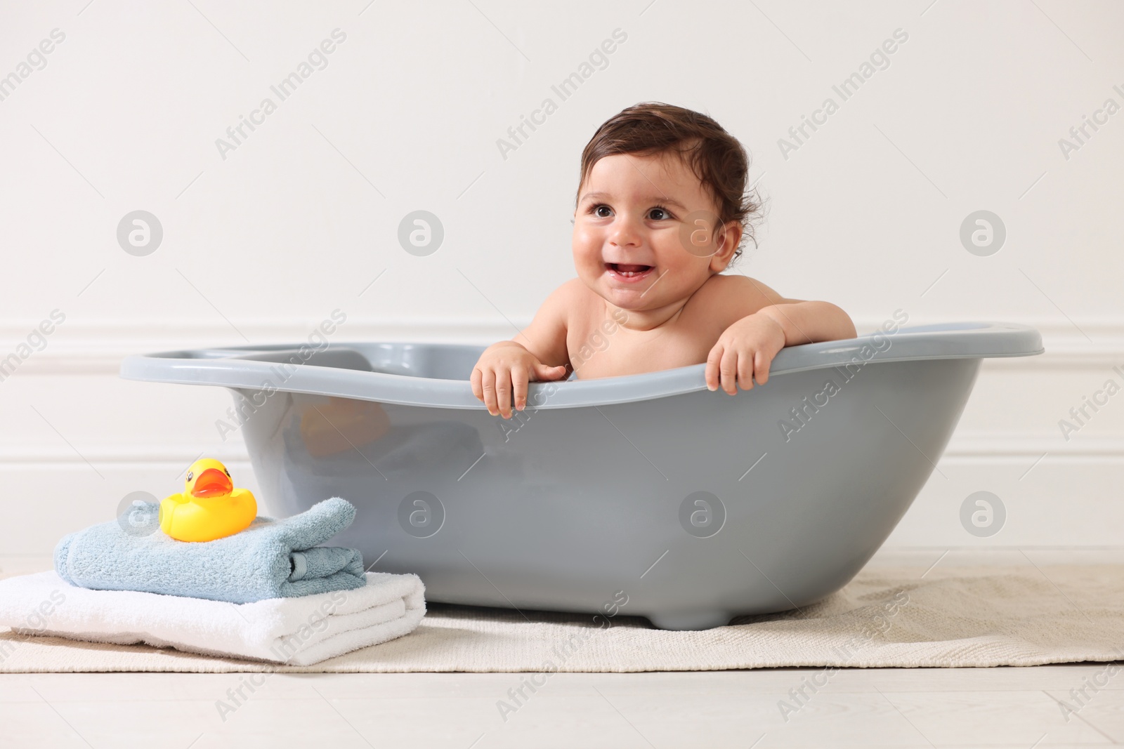 Photo of Cute little baby bathing in tub at home
