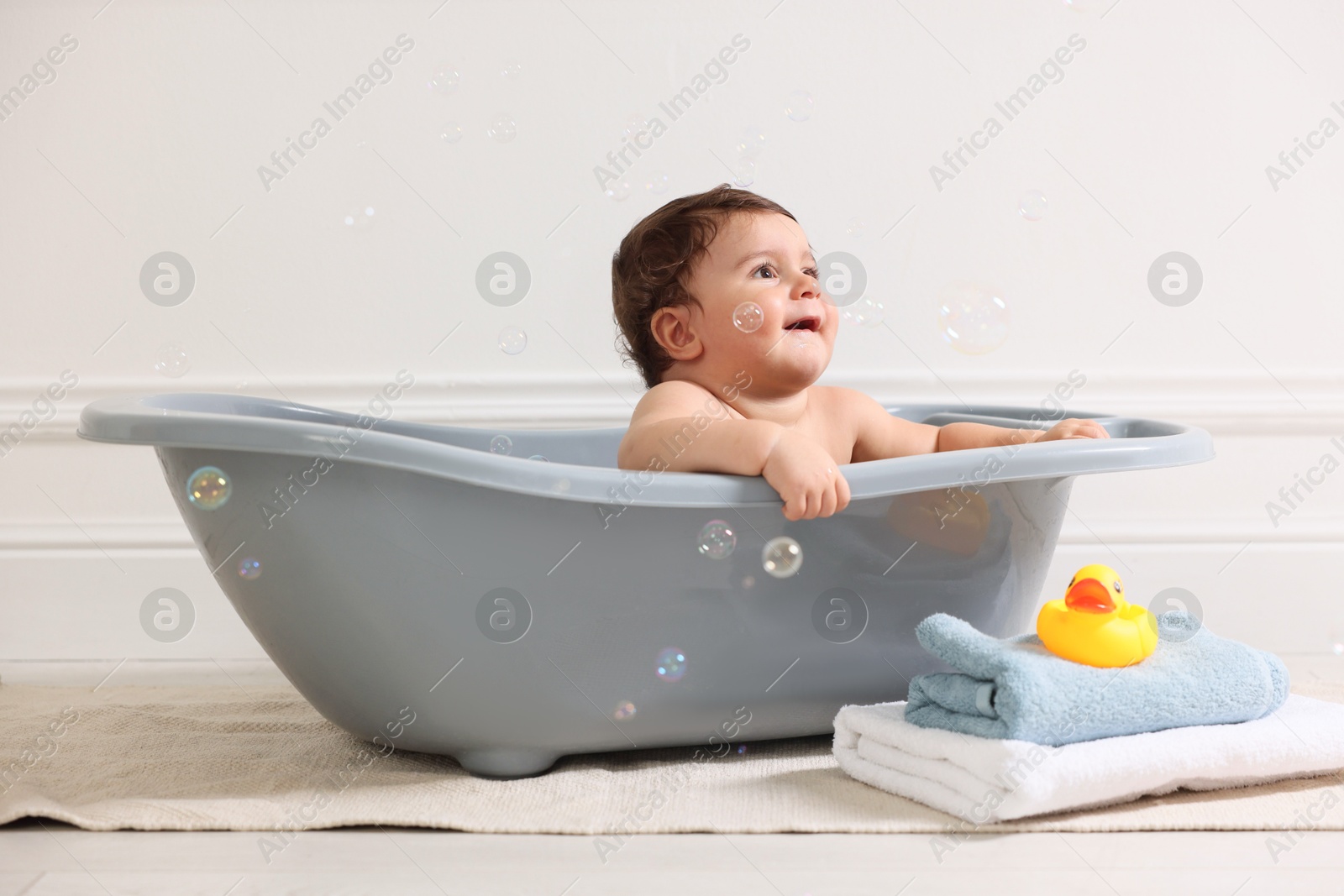 Photo of Cute little baby bathing in tub at home