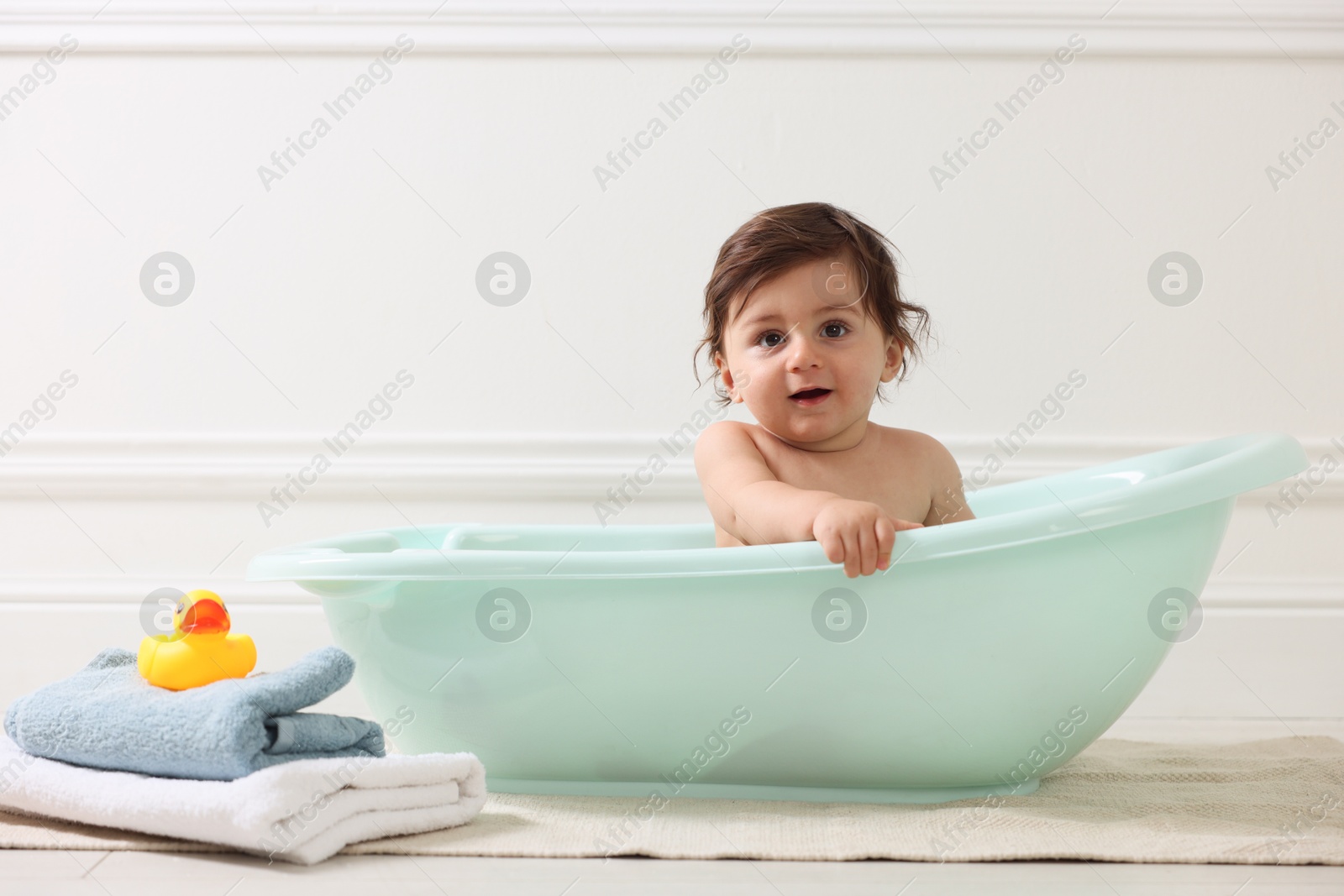 Photo of Cute little baby bathing in tub at home