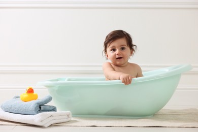 Photo of Cute little baby bathing in tub at home