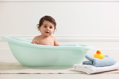 Photo of Cute little baby bathing in tub at home