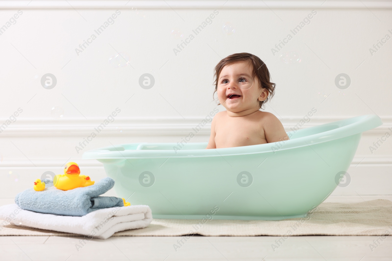 Photo of Cute little baby bathing in tub at home