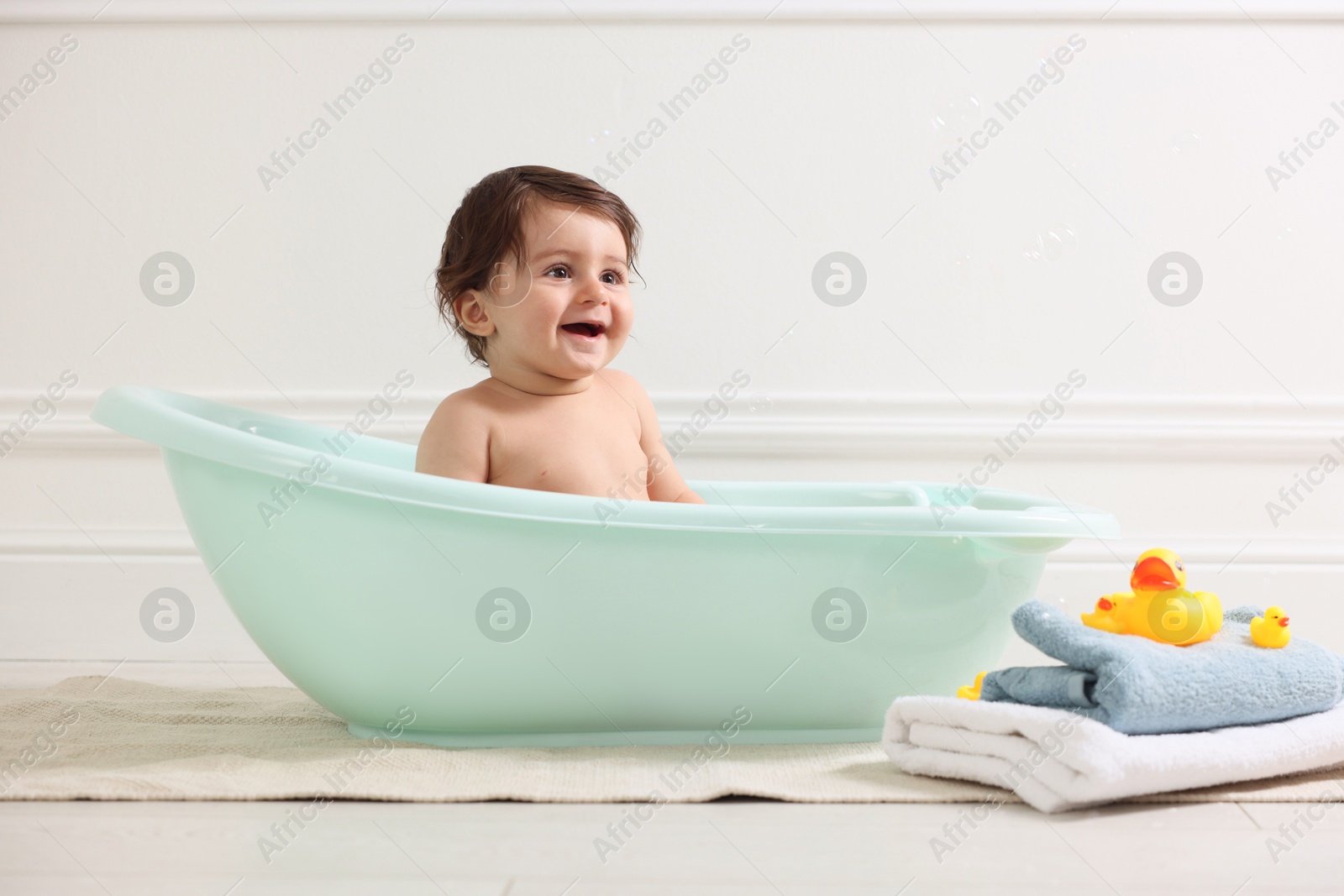 Photo of Cute little baby bathing in tub at home