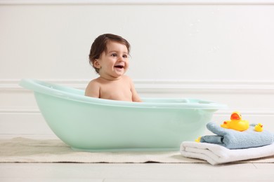 Photo of Cute little baby bathing in tub at home