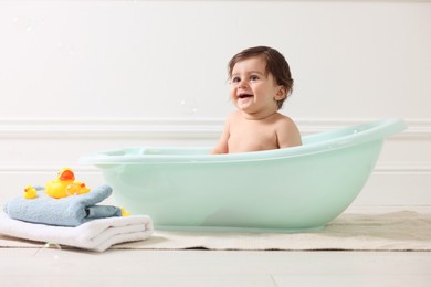 Photo of Cute little baby bathing in tub at home
